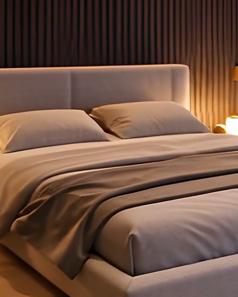 Linen bedding and pillows on a low upholstered bed.